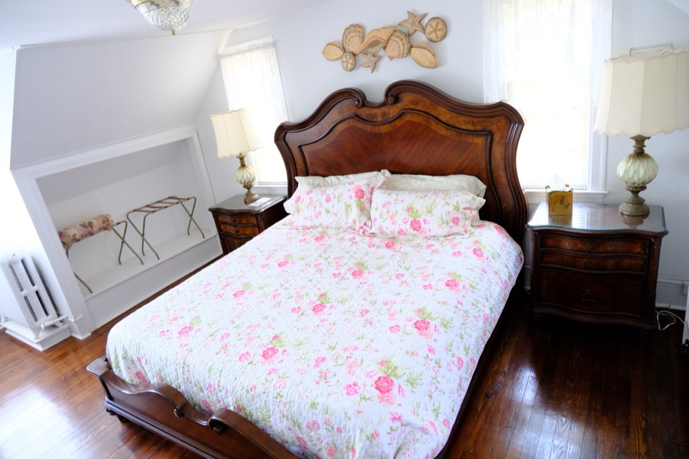 Master suite with a king bed and seashell wall art